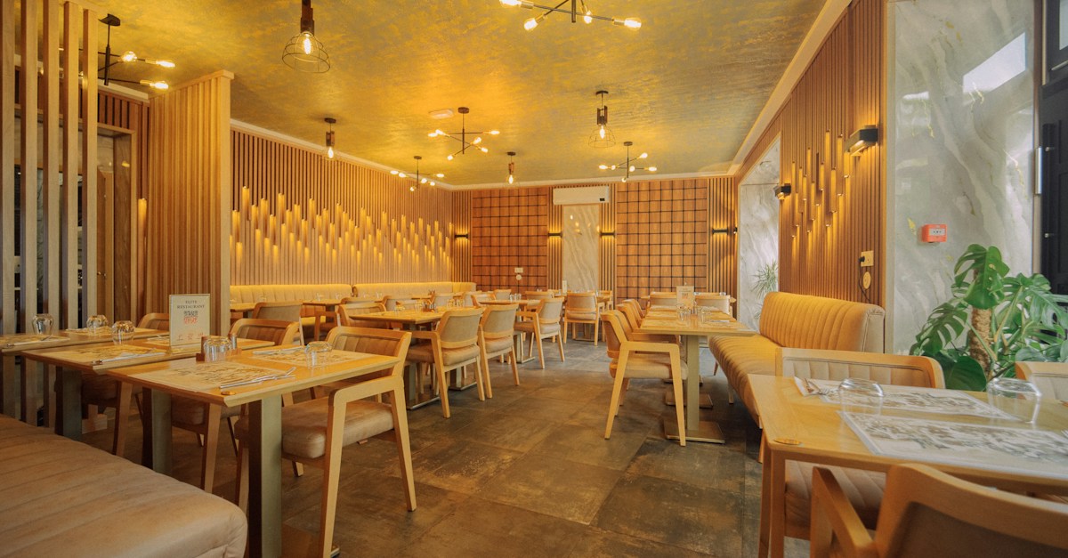 Warm restaurant dining room with ambient lighting and set tables